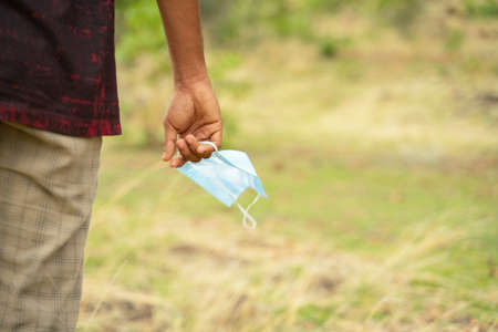 Closeup of hands holding medical mask with copy space - concept of removing mask to feel nature...