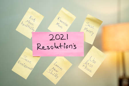 Pasted common 2021 new year resolution written sticky notes on wall.の写真素材