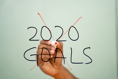 scratched out 2020 goals due to coronavirus or covid-19 pandemic on glass - concept of failed 2020 goalsの写真素材