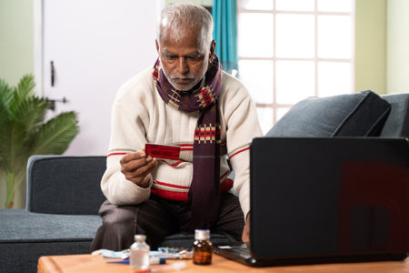 Senior sick old man entering card details for buying medicines online - concept of online medicine shoppingの写真素材