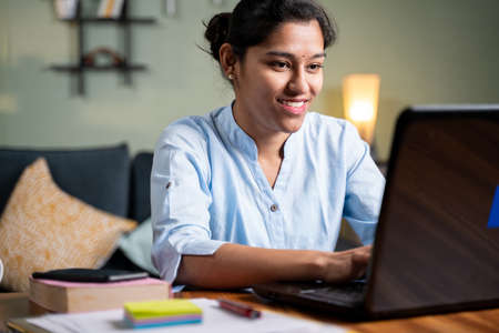 Young business girl busy working on laptop at home in formal wear - concept of professional IT employee during work from homeの写真素材