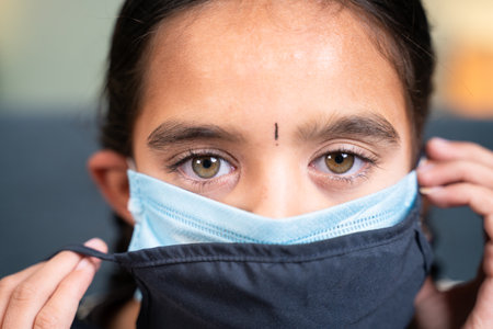 Close up head shot of girl wearing double or two face mask to protect from outbreak - concept of safety, healthcare, medical and hygiene.の写真素材