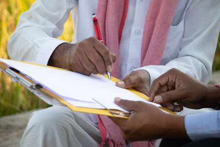 Selective focus on farmer hands, Close up of farmer hands signing on documents while sitting near...