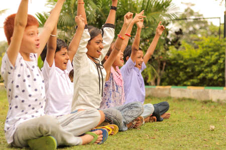 Side view, Group of young children cheering up at park - teens having fun during summer camp vacation - Multi ethnicity children playing joyful by braking the racism.の写真素材