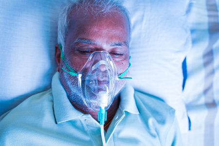 Close up Top view head shot of old breathing with ventilator oxygen mask at hospital due to...