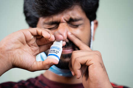 Close up head shot of young man by removing Medical face mask inhalingの写真素材