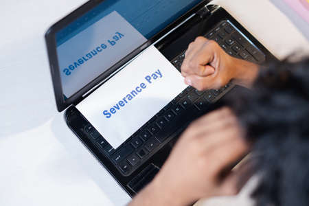 Worried employee unexpectedly receives severance pay notice while working in office - Concept of dismissal , job loss, notice of termination and unemployment during Coronavirus or covid-19 pandemic.の写真素材