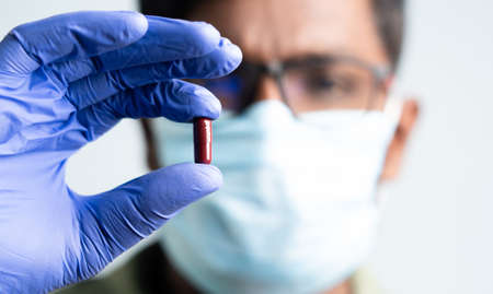 Maski, India - October,16, 2022 : Close up of doctor holding molnupiravir antiviral drug against coronavirus covid 19 outbreakのeditorial素材