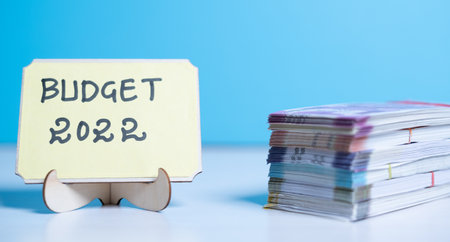 Concept of planning or setting budget for new year 2022 showing by stack of currency notes next to Budget 2022 sign boardの写真素材