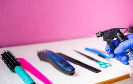 Closeup shot of hand santizing barbering equipments before haircut at saloon - concept of hygiene,...