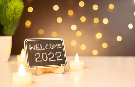 concept of 2022, - closeup shot of welcome 2022 sign board decorated party lighting background - concept of celebrating New Year and Copy spaceの写真素材