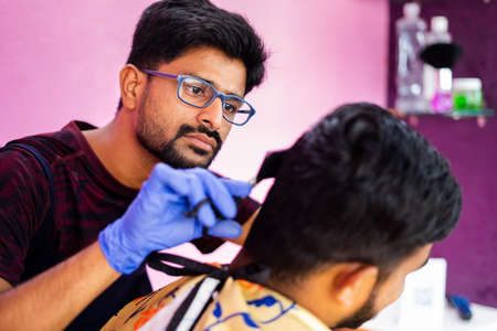Close up shot of hairdresser busy in haircut at salon - concept of haircare, professional occupation...