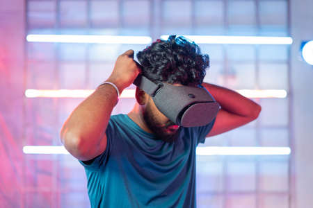 Professional gamer wearing VR by with mobile inside the headset before playing - concept of modern...