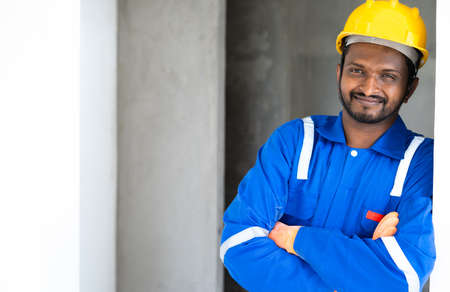 Portrait of smiling Plumber or handyman standing with crossed arms by loooking at camera with copy space -concept of successful professional occupation and ready for repair or maintenance serviceの写真素材