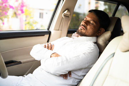 tired cab driver resting or sleeping by pushing car seat during break time - concept of overworked, exhausted and low business or no passengersの写真素材