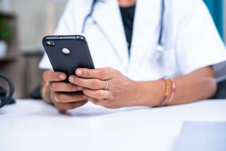 Close up women doctor hands using mobile phone at hospital - concept of relaxing, healthcare and...