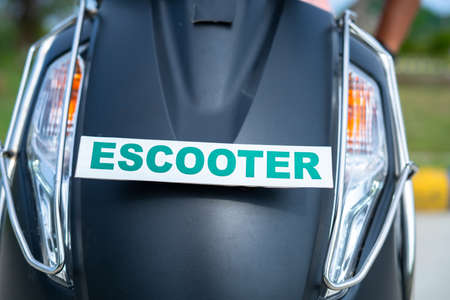 Front view of electric scooter with escooter sign board - concept of green energy, zero emission and transportationの写真素材