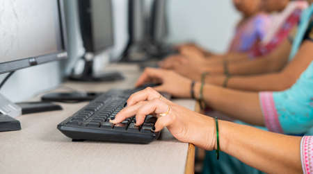 close up shot of group of women hads busy learning or working on computer at training center by typing - concept of empowerment, learning and educationの写真素材