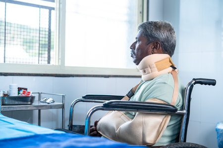Injured sad senior sick patient with neck band on wheel chair looking out fromt window - concept of...