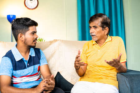 elderly grafather guiding or assisting his teenager grandson about good family values - concept of...