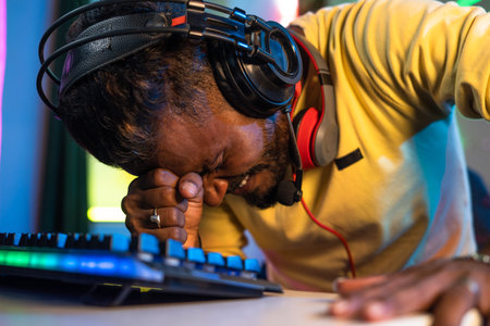close up shot of Gamer with headphones sad due to loss while playing video game on computer at home - concept of competition, online streamer and frustrationの写真素材