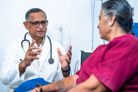 Doctor counselling admitted elderly woman at hospital - concept of medical treatment, confidence building and Mental illness or therapy.の写真素材