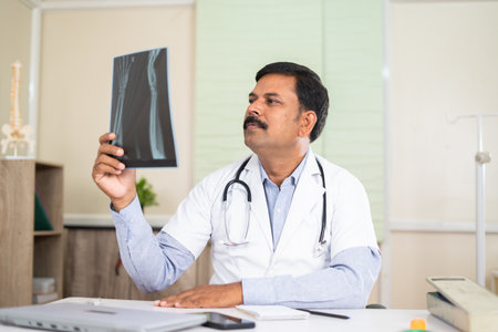 Doctor at hospital analysing x ray report - concept of healthcare treatment, professional occupation and medical expertiseの写真素材