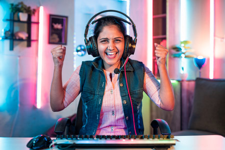 exicited gamer celebrating online live video gaming competition victory or winner by looking camera at home - concept of achievement, successful and championship.の写真素材