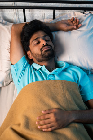 top view vertical shot of peacful young man sleeping during night - concept of relaxation, napping and wellnessの写真素材