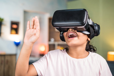 Smiling teenger girl kid with VR or virtual reality headset saying hi on video call on metaverse at...