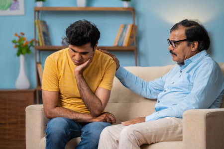 Indian senior father consoling by giving confidence to adult son at home - concept of depression, emotional comfort and caring parenthood.の写真素材