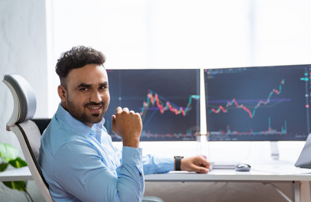 Happy smiling indian trader or stock broker by looking at camera at office - concept of successful,...