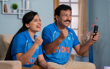 focus on father, Excited joyful father with daughter celebrating Indias win while watching Cricket live sports match on tv or television at home - concept of Proud Moment, Cricket fever and Happy Victoryの写真素材