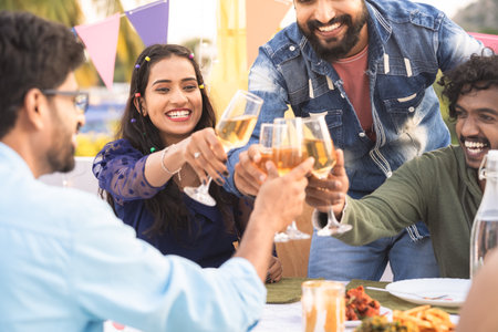 Close up shot hands starting new year party by holding clinking champagne glasses at night - concept...