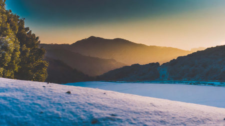 Beautiful winter landscape with snow covered mountains and blue sky at sunsetの素材