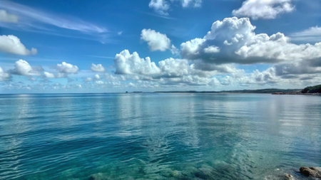 Panoramic view of the sea with blue sky and white cloudsの写真素材