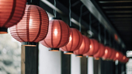 Red Chinese lanterns in a row on the wall in a restaurant