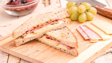 Sandwich with ham and cheese on a wooden board.の写真素材