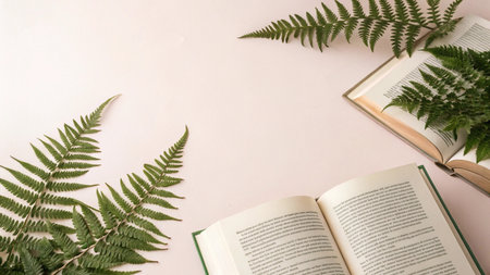 Open book with fern leaves on pink background. Flat lay, top view.の写真素材