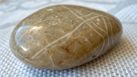 close up of a white zen stone on a white fabric background