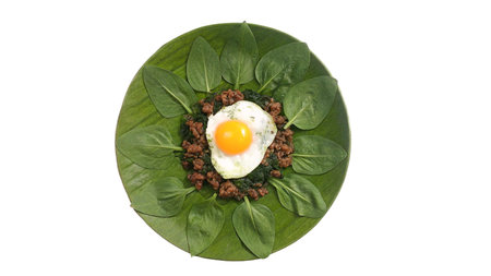Top view of spinach salad with fried egg isolated on white background.の写真素材