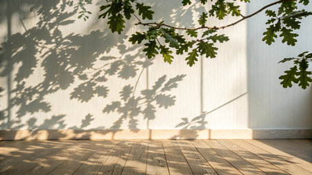 Wooden floor and shadow of tree on white wall in the roomの写真素材