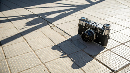Vintage camera and shadow on the pavement in a sunny day.