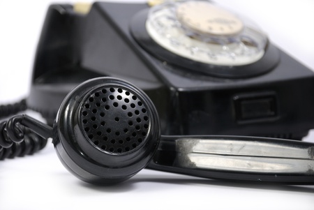 Old black phone with focus on the handset in the foregroundの写真素材