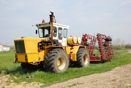Yellow tractor parked on a grass field