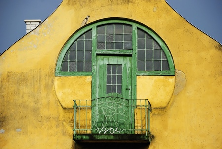 Green rustic balcony in a yellow wallの写真素材