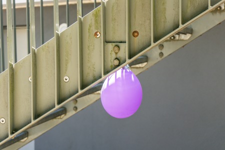single purple baloon hanging from a starの写真素材