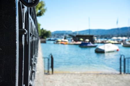 Old craftet iron fence with lake view and boatの写真素材