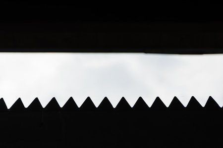 Barbed wire fence against the blue cloudy skyの写真素材