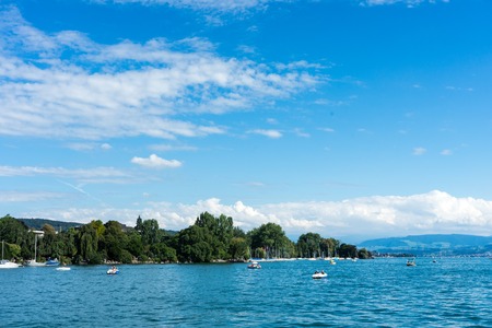 lake water view with urban city area and mountain and blue skyの写真素材